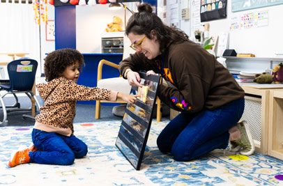 Teacher shows young girl student pictures on a board